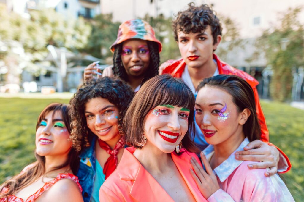 A diverse group of young people wearing brightly coloured clothes and make-up